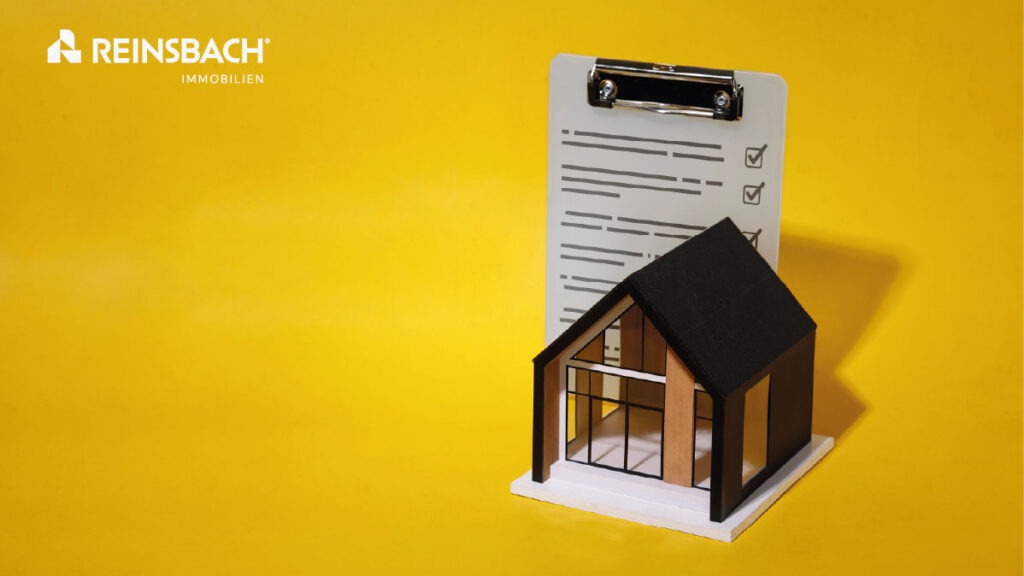 Reinsbach Immobilien Göttingen – Modellhaus vor Checkliste als Symbol für Unterlagen beim Immobilienverkauf